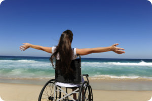 Disabled woman in the wheelchair at the beach